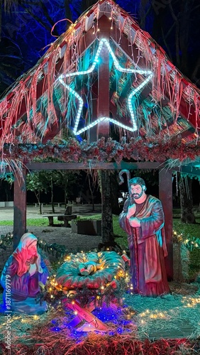 Illuminated Nativity scene at night. Christmas scene with figures representing the birth of the baby Jesus Christ in the manger.