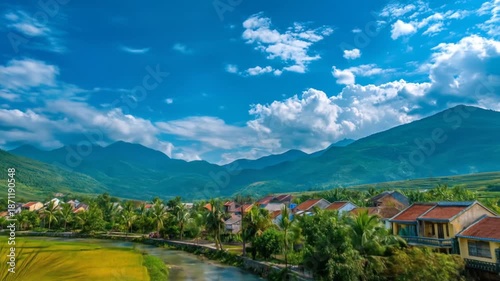 A picturesque village nestled beside a lush rice paddy, with a towering palm tree and mountains in the background under a vibrant blue sky.
