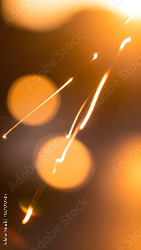 Abstract bright golden light trails create a dynamic and energetic visual effect, with glowing bokeh circles softly blurred in background, depicting movement and warmth in an artistic composition