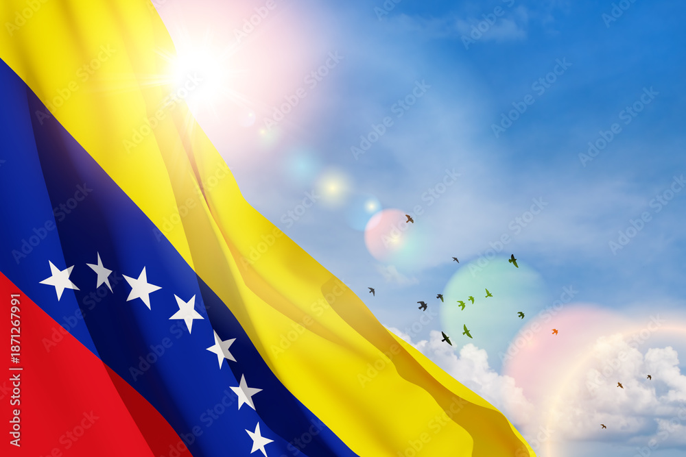 Obraz premium Venezuela flag on background of blue sky with flying birds. Patriotic concept. Banner with place for text.