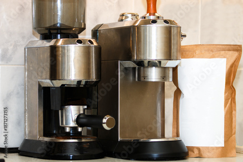 Obraz na płótnie Industrial style coffee maker and burr grinder with blank coffee bag on marble surface