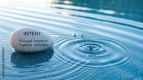 Smooth stone with inspirational message creating gentle ripples in tranquil azure water
