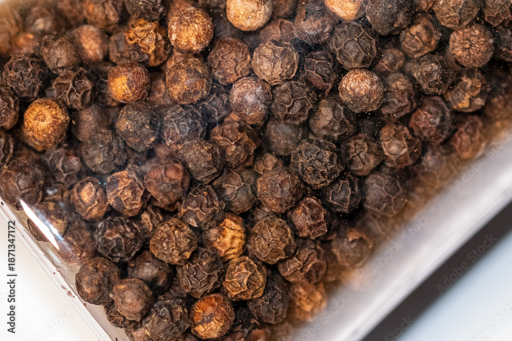Obraz premium macro shot of dried black peppercorns texture on white background 