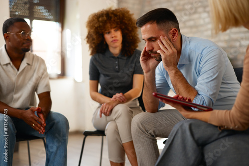 Fotografie Empathetic colleagues supporting a stressed coworker in a group meeting