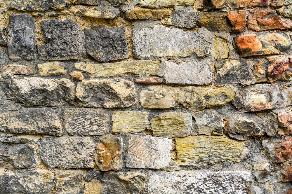 Fototapeta premium A background of old brickwork and unevenly shaped stones. Horizontal color photo