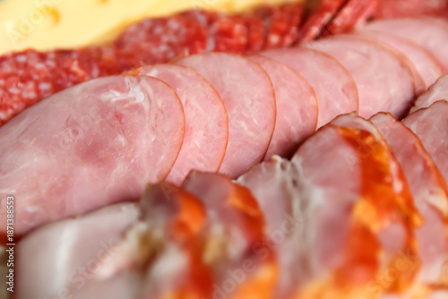 Close-up view of an assortment of sliced deli meats and sausages, including ham, salami, and smoked meats. Gourmet Deli Meat Platter. assorted deli cold cuts ham and salami