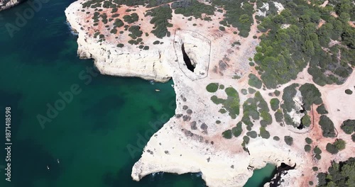 Aerial drone view of Benagil sea caves and Atlantic Ocean coastline in Benagil, Algarve, Portugal, Europe. Boats and kayaks sightseeing. Cinematic grading