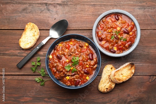 Fotografia Delicious chili con carne served on wooden table, flat lay