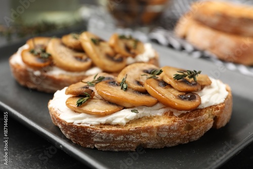 Obraz na płótnie Tasty bruschettas with cream cheese, mushrooms and thyme on table, closeup