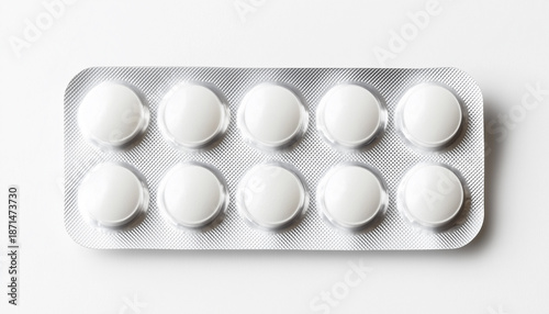 One full blister pack of ten empty white pills or tablets, isolated on a white background. The silver foil packaging contains round