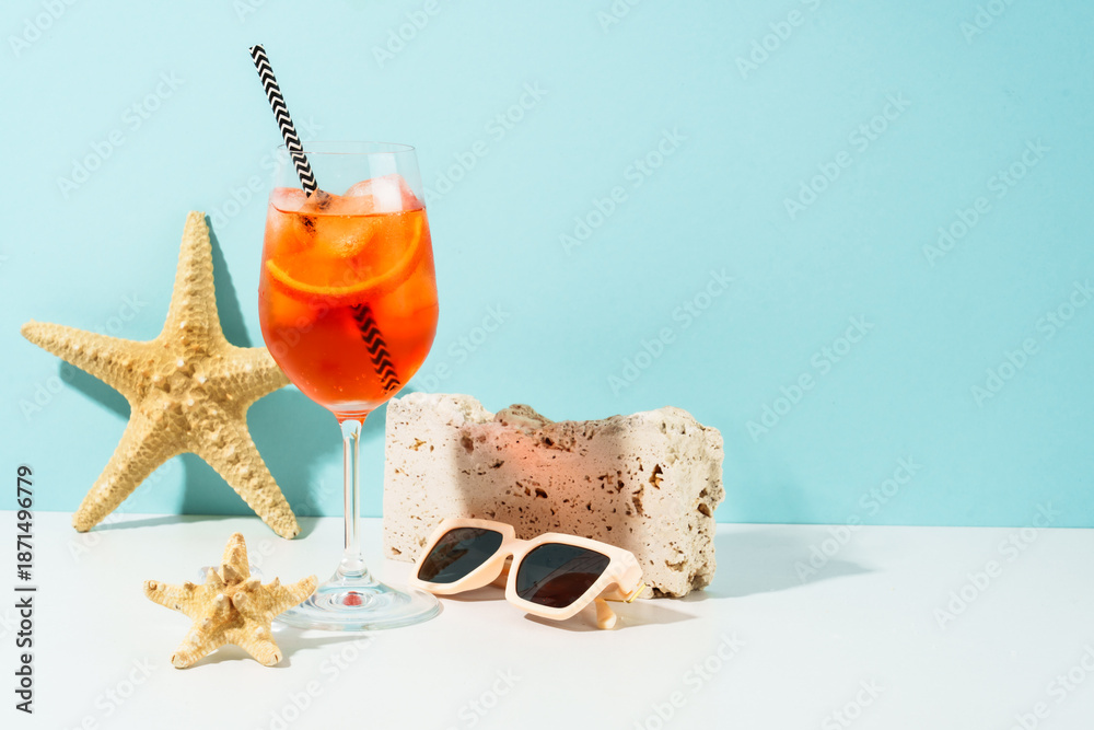 Naklejka premium Aperol Spritz, Summer alcohol cocktail drink at blue background.