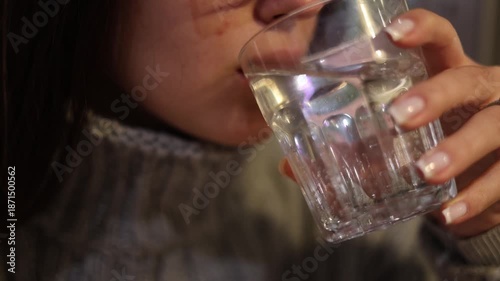 Young woman drinking clean water from glass feeling thirst refreshment and hydration calm lifestyle moment at home natural light healthy daily habit wellness concept