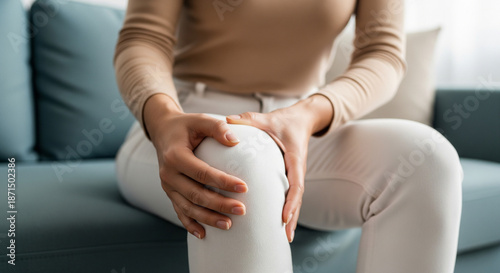 Woman Holding Painful Knee at Home – Lifestyle Health Photo of Joint Discomfort in Calm Modern Interior