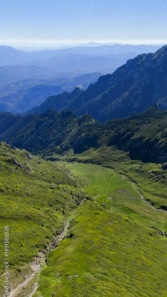 Fototapeta premium Mountain ridge, green peak, and rocky slope aerial view