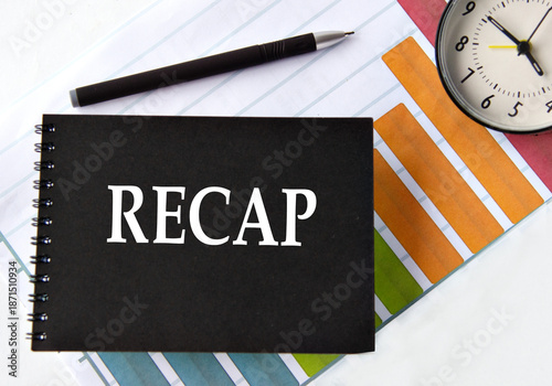 RECAP - word on a black notebook with a chart and alarm clock in the background