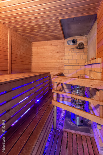 Inside of usual standart wooden sauna room interior with stone and brick with blue backlight