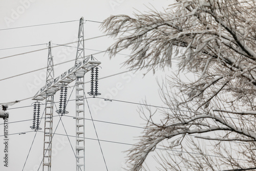 High-voltage powwr lines wires and poles are covered with frost on a frosty winter day.