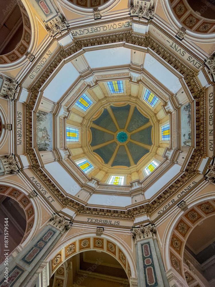 Obraz premium Messina, Sicily, Italy - July 18, 2024: Tempio di Cristo Re, Temple of Christ the King. Inside, looking up into the dome with words from In consilio sanctorum magnus et terribilis super omnes qui in c