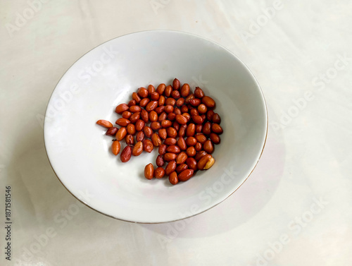 Peanuts served in white bowl on clean background