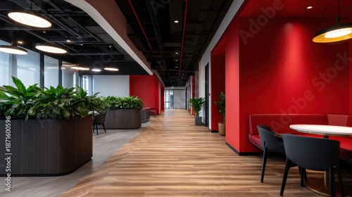 A modern open-plan office corridor with red accent walls, wooden flooring, and leafy planters. Bright halls!!!