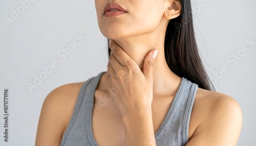 Woman experiencing throat pain, discomfort, or thyroid issues.