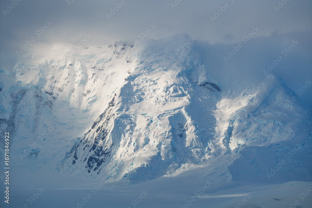 Fototapeta premium Stunning Antarctica Mountain With Beam of Sun Light. Fine Art Photography Snow Covered Landscape Magical Heavenly Close Up Nature Abstract Texture