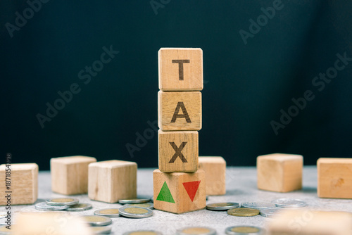 Stack of wooden cubes with the word Tax and arrows pointing up and down. Trends in tax rate changes (up or down). Business and financial tax concepts. Tax rates, percentages, and calculation concepts.
