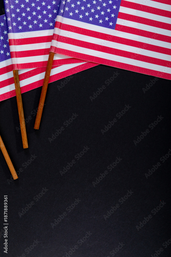 Fototapeta premium Red and white stripes along with stars on usa flag sticks by copy space on black background