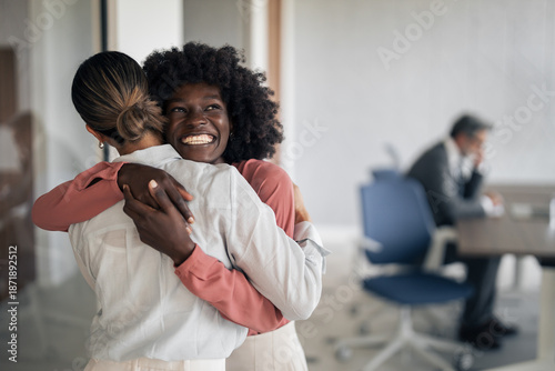 Fényképezés Happy diverse colleagues embracing in office for team success