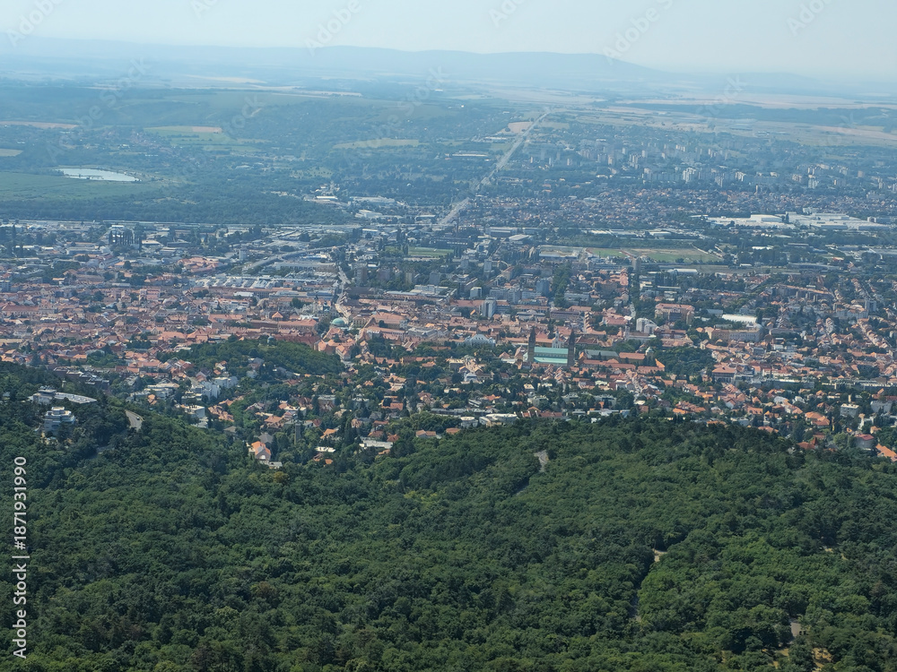 Obraz premium Fourteenth image in a series featuring a panoramic view of the city of Pécs, Hungary, captured from the observation deck of the TV tower. Elevated viewpoint highlighting the urban landscape, rooftops,