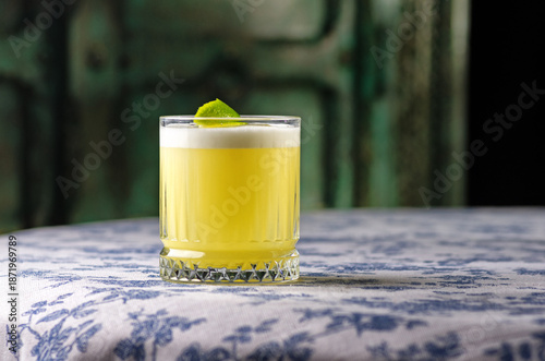 Pisco sour cocktail - whiskey with lime, egg white, sugar syrup in glass on dark background. Space for text