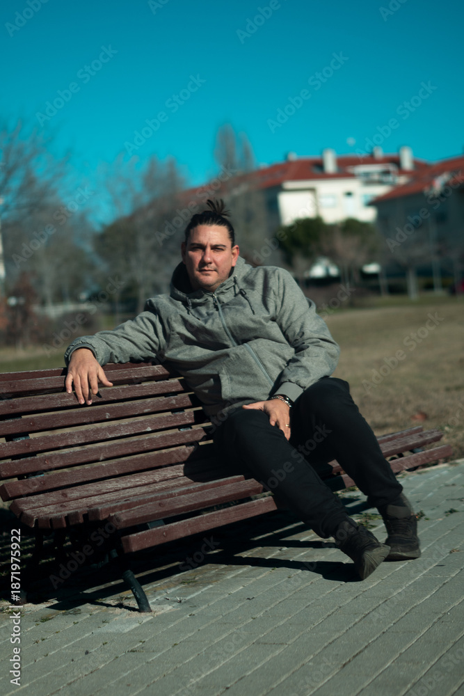 Fototapeta premium Man relaxing on park bench enjoying leisure time