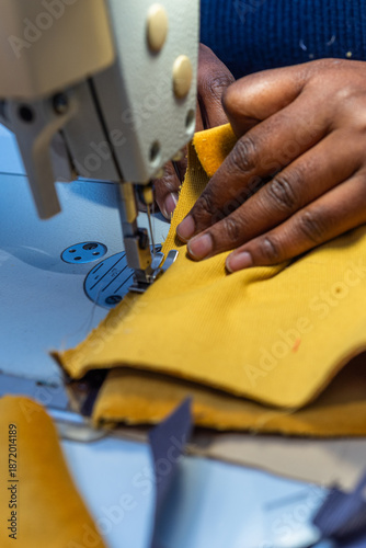 Black woman sews fabric with sewing machine