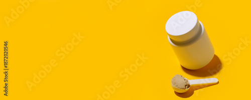 Scoop of Whey protein powder. Sports nutrition. Fitness diet and food concept - whey and soy protein shake powder, collagen on bright yellow background, copy space, banner, flyer
