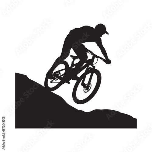 Silhouette of a mountain biker riding downhill on a steep rocky terrain