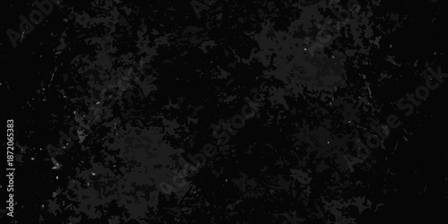 Dark abstract texture with grainy appearance and scattered speckles of light