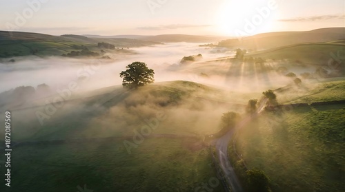 Tableau sur toile Aerial view of misty countryside landscape at sunrise over green rolling hills
