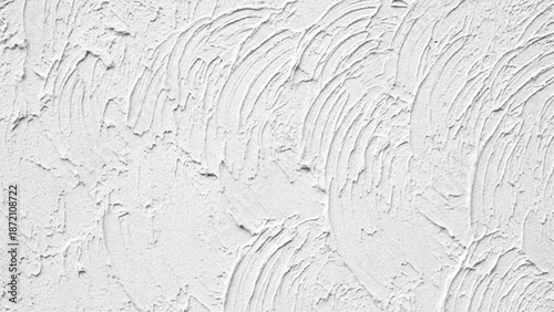 Textured white wall with curved plaster patterns, a close-up of rough surface detail