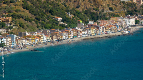 Wallpaper Mural Aerial view of a vibrant coastal town nestled between a lush green hillside and the deep blue sea. It is the Giardini Naxos waterfront, located in province of Messina, Sicily, Italy. Summer morning. Torontodigital.ca