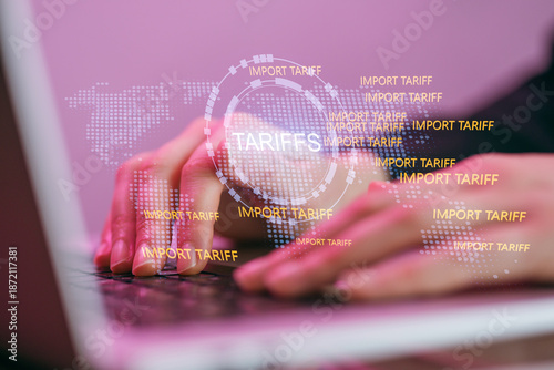Obraz na płótnie Hands typing on a laptop with import tariffs and a world map showing trade conce