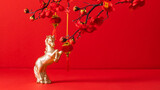 Chinese New Year of the Fire Horse. A golden horse figurine on a red background with Chinese lanterns and flowering branches. Festive atmosphere of the Lunar New Year.