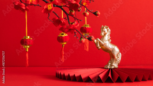 2026 Year of the Fire Horse on a red background. A plum blossom branch and traditional red lanterns, a golden horse figurine on a red paper fan, symbolizing good luck and the Spring Festival