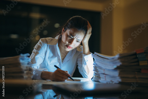Foto Young professional woman experiencing stress and frustration while working late