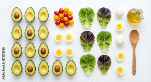 Healthy food flat lay composition with avocado, eggs, tomatoes, lettuce and olive oil arranged on white background