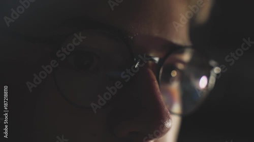 Close-up Teen Boy Face in Dark, Green Screen Glow Reflection in Glasses, Handheld Shot, Night Coding Gaming