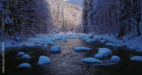 Peaceful flight over a snow-covered alpine stream. Flowing icy water, frozen rocks, and fresh snow create a calm winter atmosphere ideal for relaxation, meditation, and nature visuals.