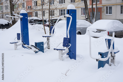 Bild auf Leinwand Outdoor gym machines stand empty and half-buried in deep fresh snow in a residen