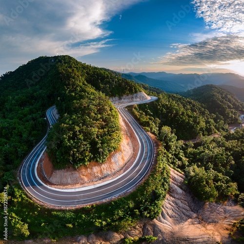 Aerial View of Scenic Winding Mountain Road Through Dense Green Forest, Curved Highway Landscape in Summer Nature, Drone Photography of Serpentine Road in Hills, Travel and Transportation Concept