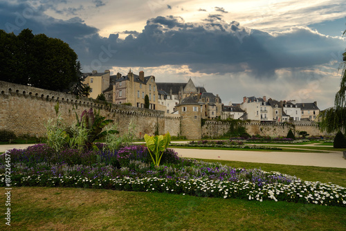 Historic medieval ramparts of Vannes overlooking landscaped gardens, with stone walls and traditional houses under a dramatic sky, showcasing Breton heritage, urban fortifications, and the harmony bet