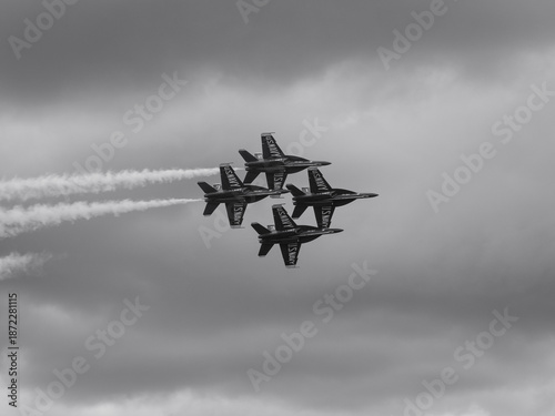 Naval Airshow, F-18 Super Hornet jets flying in formation on beautiful summer day high in the clouds